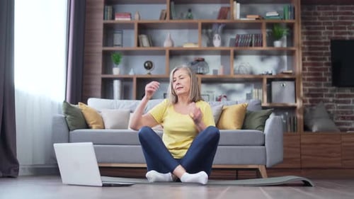 Senior Woman Stretching Arms at Home