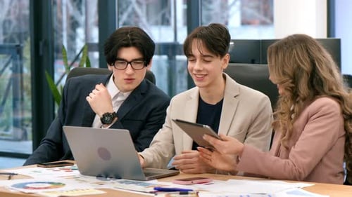 Business meeting in an office, female team leader and two young workers discussing business affairs