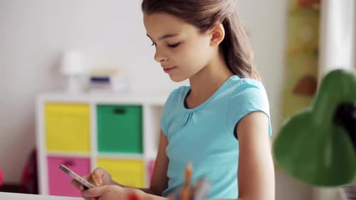 Girl Using Phone in Room at Desk Indoors