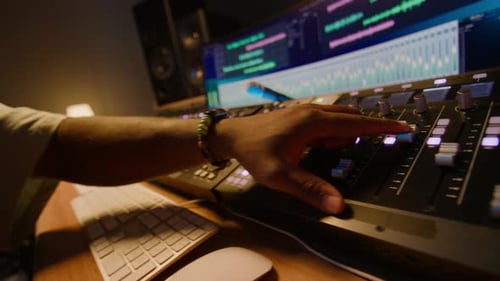 Man Adjusting Audio Mixer in Recording Studio