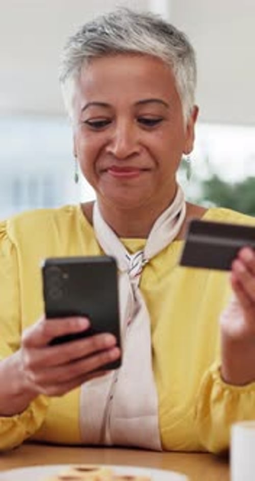 Woman Using Phone and Credit Card At Home