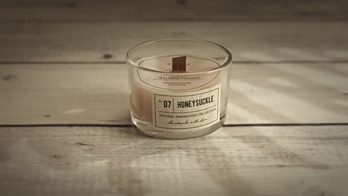 Descendez sur une tasse de bougies faites maison sur une table en bois crème.