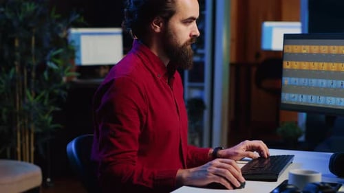 Man Working at Computer in Dark Office at Night