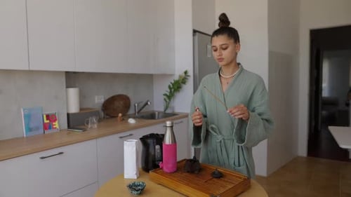Woman Prepares Incense in Kitchen for Spiritual Practice