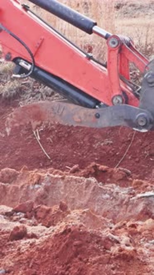 Excavator Digging Dirt in Rural Area on Sunny Day
