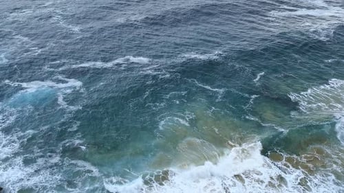 The waves of blue Cantabrian sea hitting the beach of the Isla island