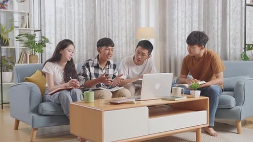 Groupe d'adolescents asiatiques étudiant sur un ordinateur portable à la maison. Suivre un cours en ligne, un garçon en chemise à carreaux
explique