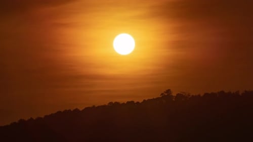 Sunset over a mountain in the orange sky 4k time lapse video.