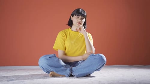 Woman Sitting Cross-Legged Deep in Thought Indoors