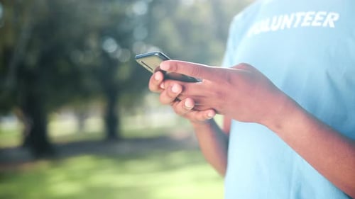 Volunteer Typing on Smartphone in Sunny Park