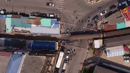Drone shot of Maeklong Railway Market with train passing, Thailand
