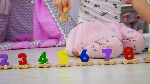 Child Plays with Colorful Wooden Number Train