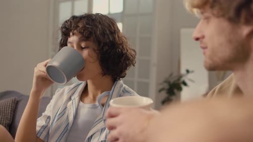 Woman with Black Curly Hair Drinking Tea