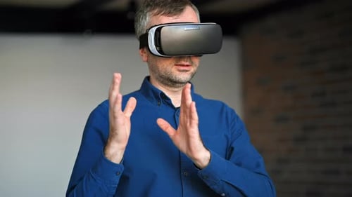 Man gesturing while using a Virtual Reality headset in an office