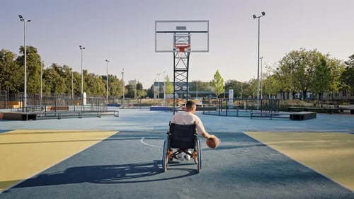 Man in Wheelchair Playing Basketball on Urban Court