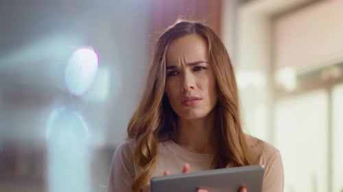 Thoughtful businesswoman works on digital tablet at home office in slow motion