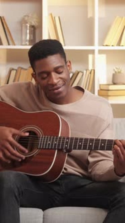 Man Plays Guitar and Sings at Home