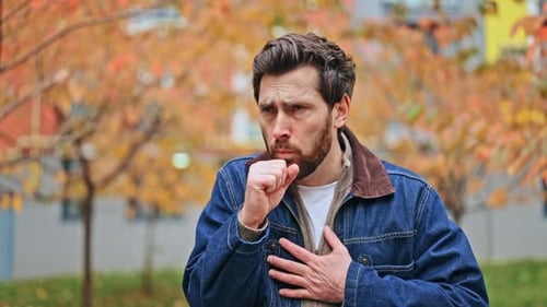 Man Coughing in Urban Environment During the Day