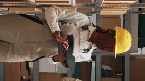 Vertical Video Female Employee in Overalls Checking Tablet Inventory