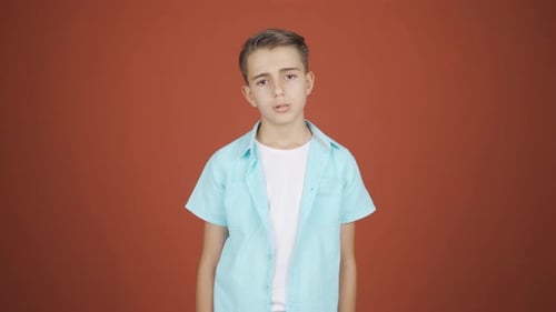 Boy looking depressed at camera.