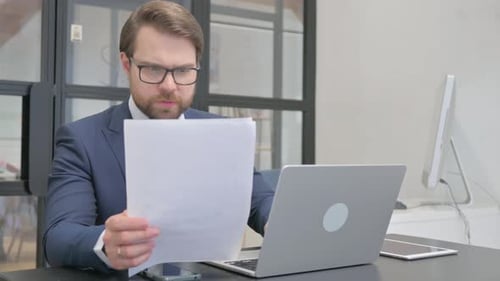 Professional Man Works on Laptop at Modern Desk
