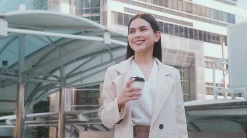 Young beautiful business woman holding coffee cup ready to work in modern city