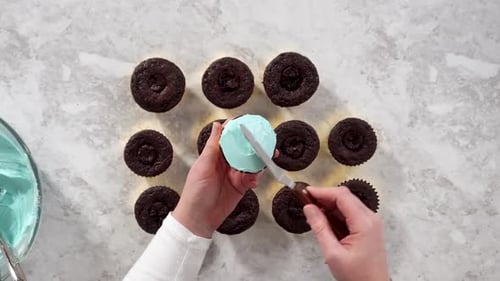 Flat Lay Decorating Chocolate Cupcakes with Buttercream Frosting and Rainbow Candy