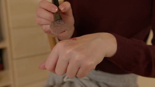 Woman Applying Makeup with Brush at Home