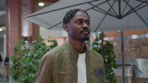 Young Man Smiling Walking In Mall Under Umbrella