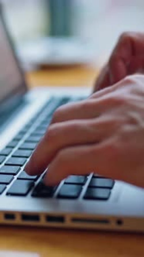 Bild von Männerhänden, die auf einem Laptop tippen. Selektiver Fokus. Video zum Geschäftskonzept. Vertikales Video