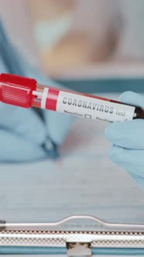 Coronavirus Test Tube Held by Gloved Hand