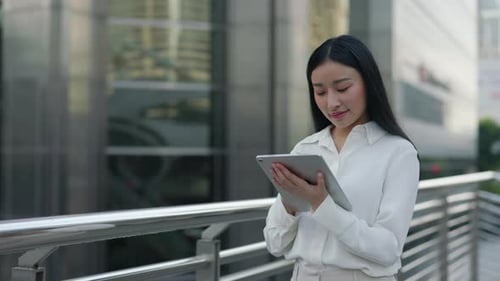 Beautiful Modern Girl Standing on Street and Using Tablet Drawing on It with Digital Pen
