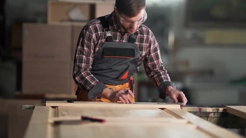 Woodworker Measuring Wood in Workshop with Ruler