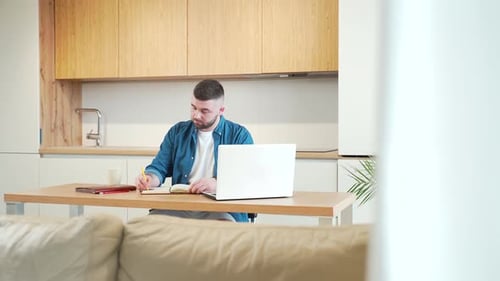 Man Working at Laptop in Modern Kitchen