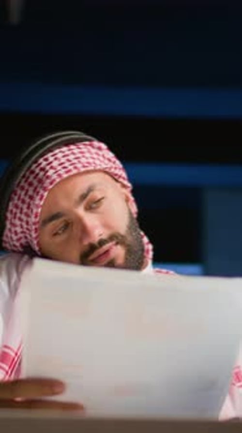 Adult Man Talking on Phone While Reviewing Documents