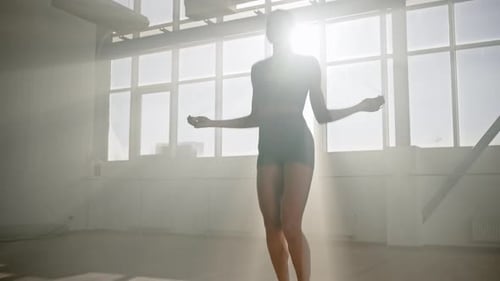Ansicht von unten einer ethnischen Sportlerin, die im Fitnessstudio mit Springseil trainiert