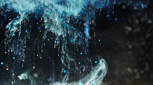Close-up of blue ink dispersing in water with tiny bubbles and particles, creating a mesmerizing eff