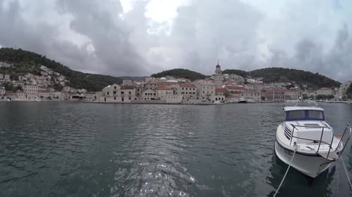 Brac Island, Croatia. Traditional fishing boat in the port. View of the city.