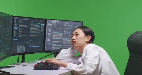 Asian Woman Developer Boring While Write Code With Multiple Screens In Green Screen Studio