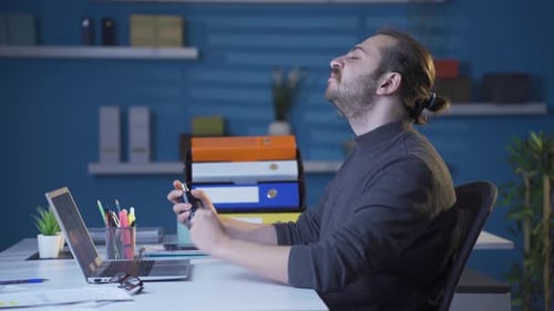 Man Sprays Cologne on Neck in Office