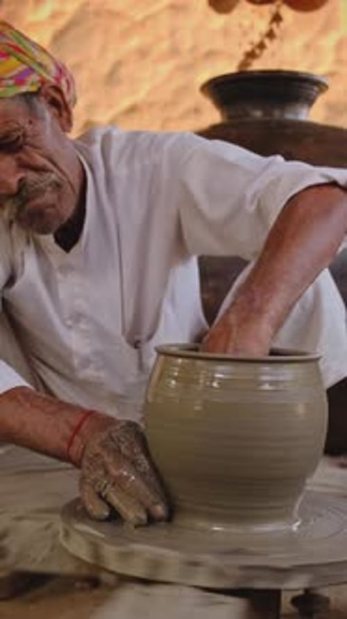 Potier indien lançant un tour de potier et façonnant un pot en argile dans un atelier de poterie en Inde