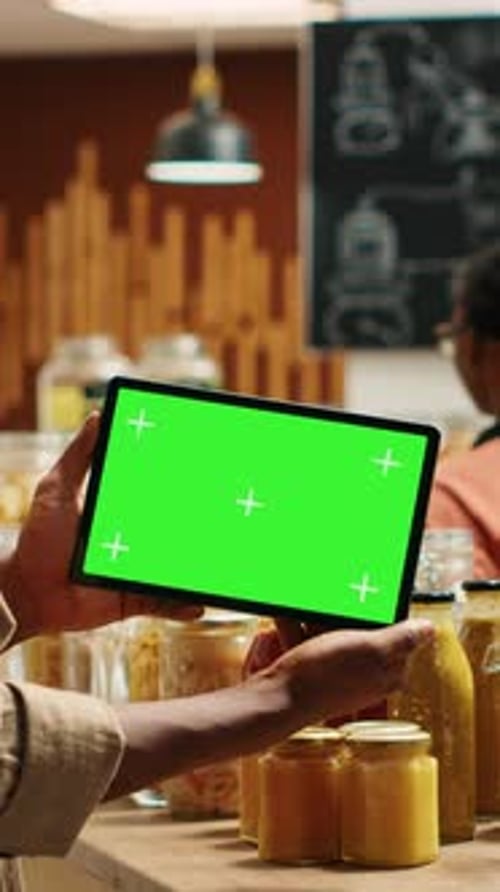 Vertical Video African American Buyer Shows Tablet with Greenscreen Template in Grocery Store