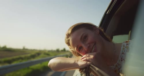Joyful Woman Enjoys Car Ride in Rural Setting