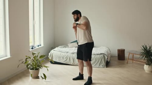 Young Bearded Guy Training at Home Rotating His Hips