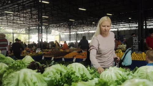 A Young Woman is Shopping at the Farmer's Market of Organic Products