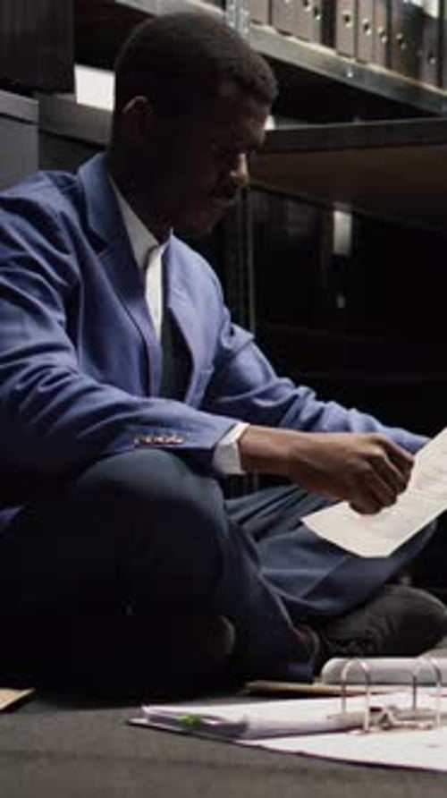 Man in Suit Reads Documents in Office