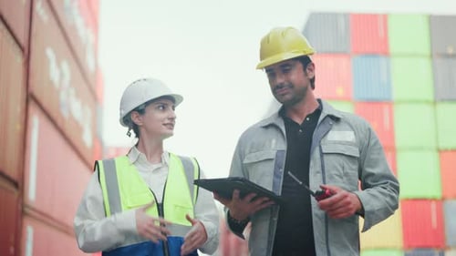 Workers Discussing Shipping Logistics in a Container Yard