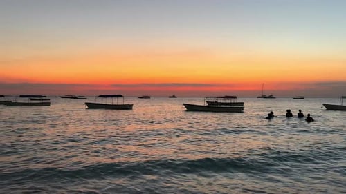 Puesta de sol, océano y barco con la silueta de un grupo de buceadores, aventura de viaje al aire libre