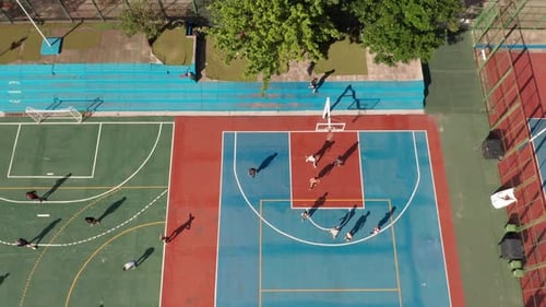 Sports Ground With Athletes Playing Basketball And Soccer On Respective Fields. aerial sideways