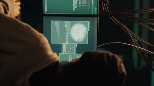 Person Faces Many Monitors Displaying Code